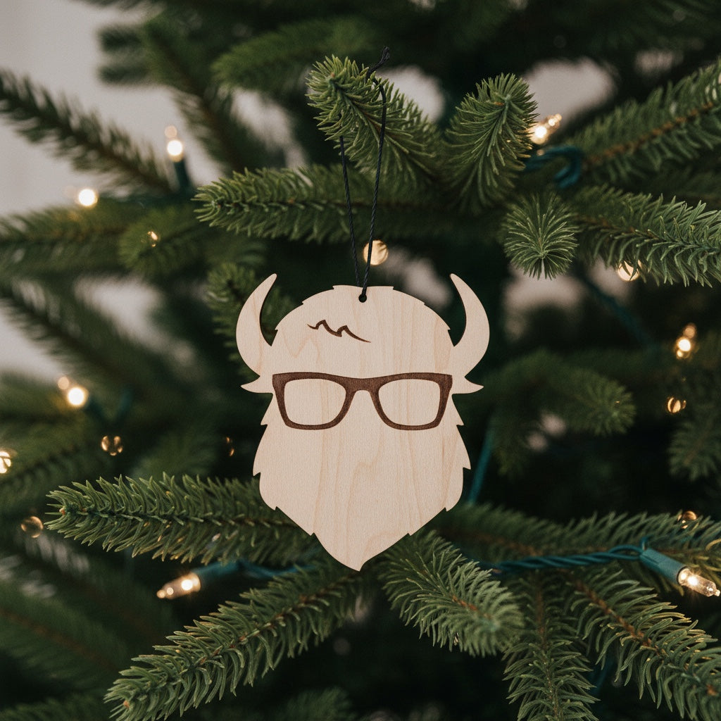Curious Bison wooden logo ornament hanging on a Christmas tree with lights, laser cut wood holiday ornament for Tulsa souvenir and small business gift