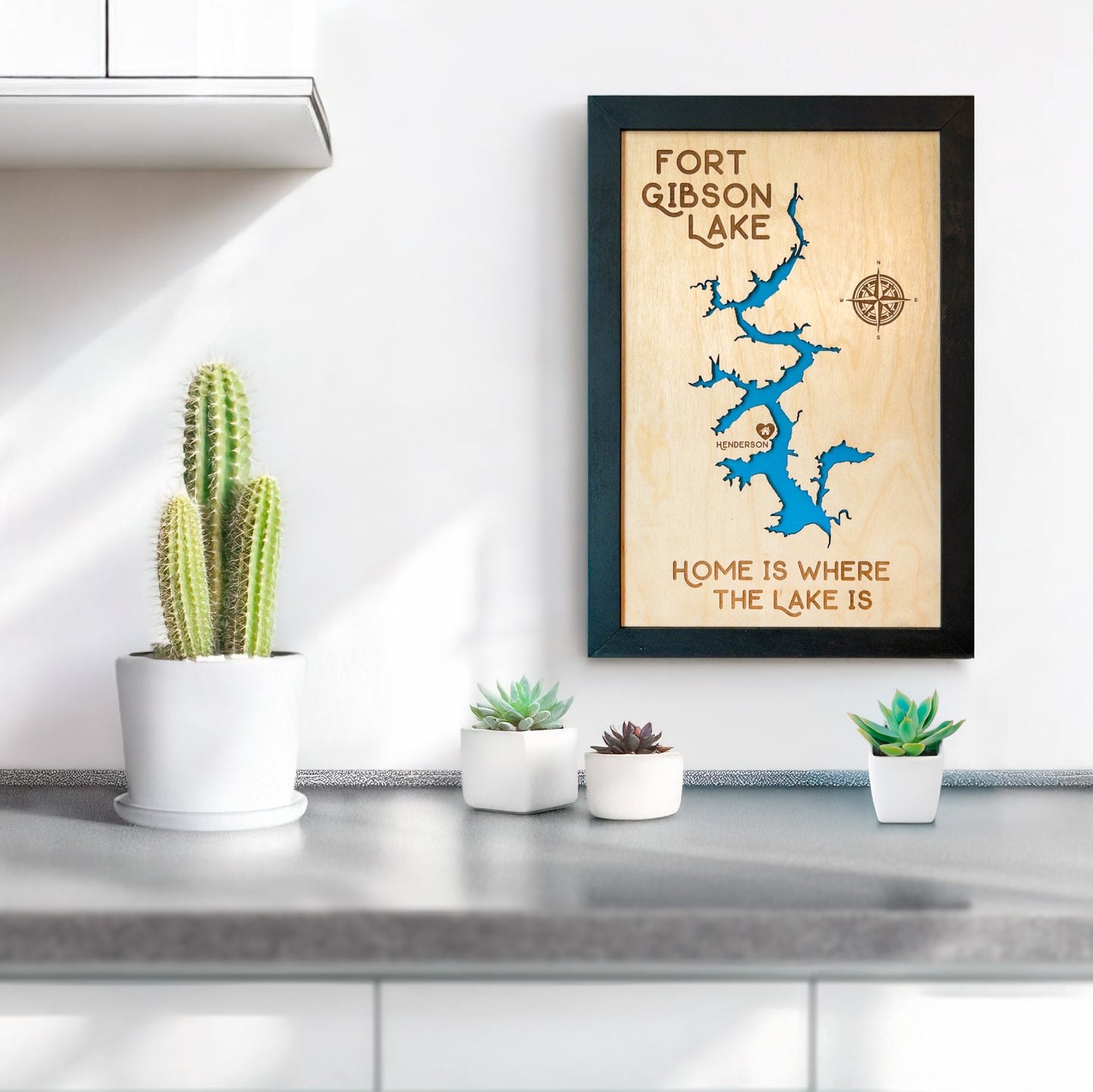 Fort Gibson Lake wooden map wall art displayed above a countertop with plants