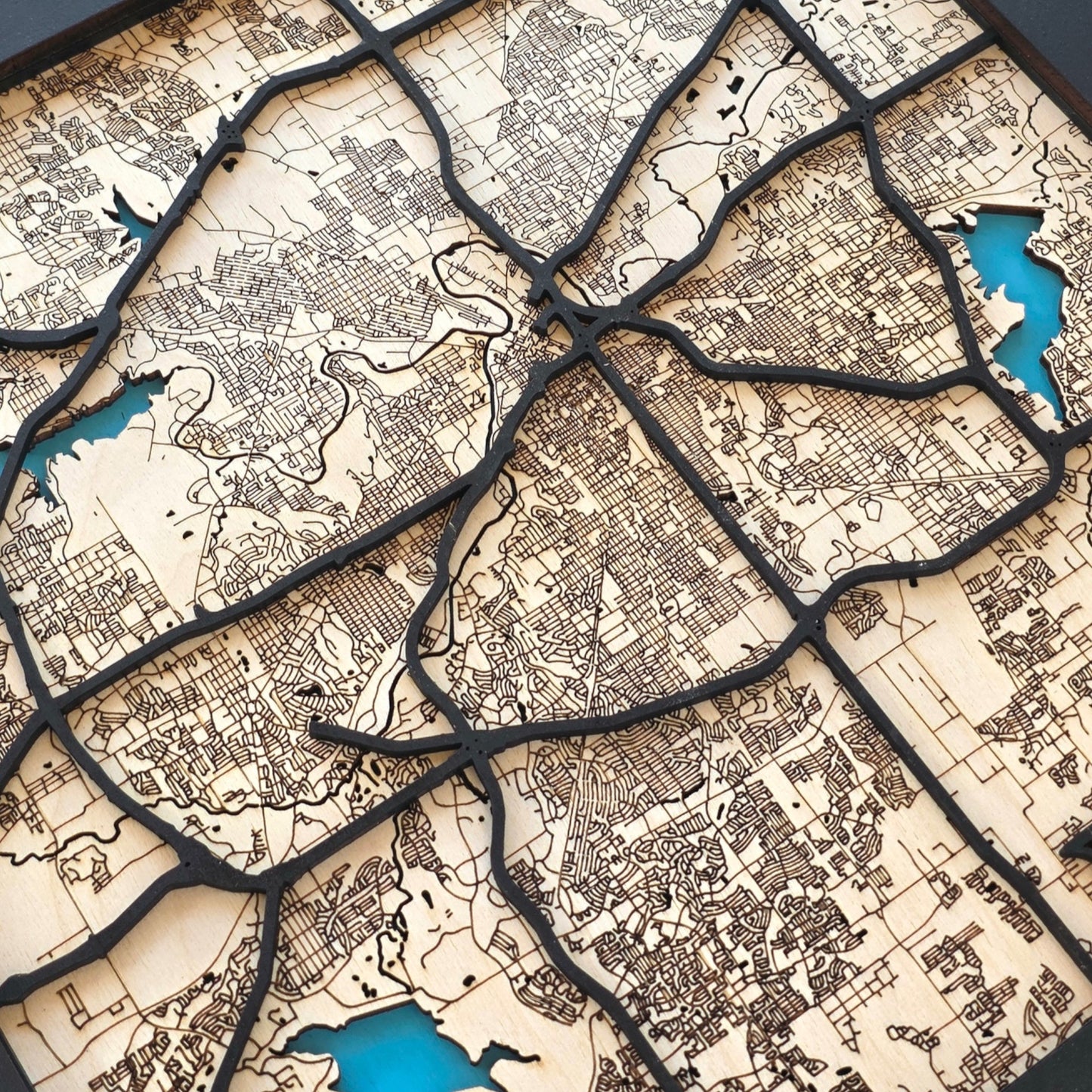 close up of Fort Worth wood map showing layered road lines and engraved street details with natural wood tones