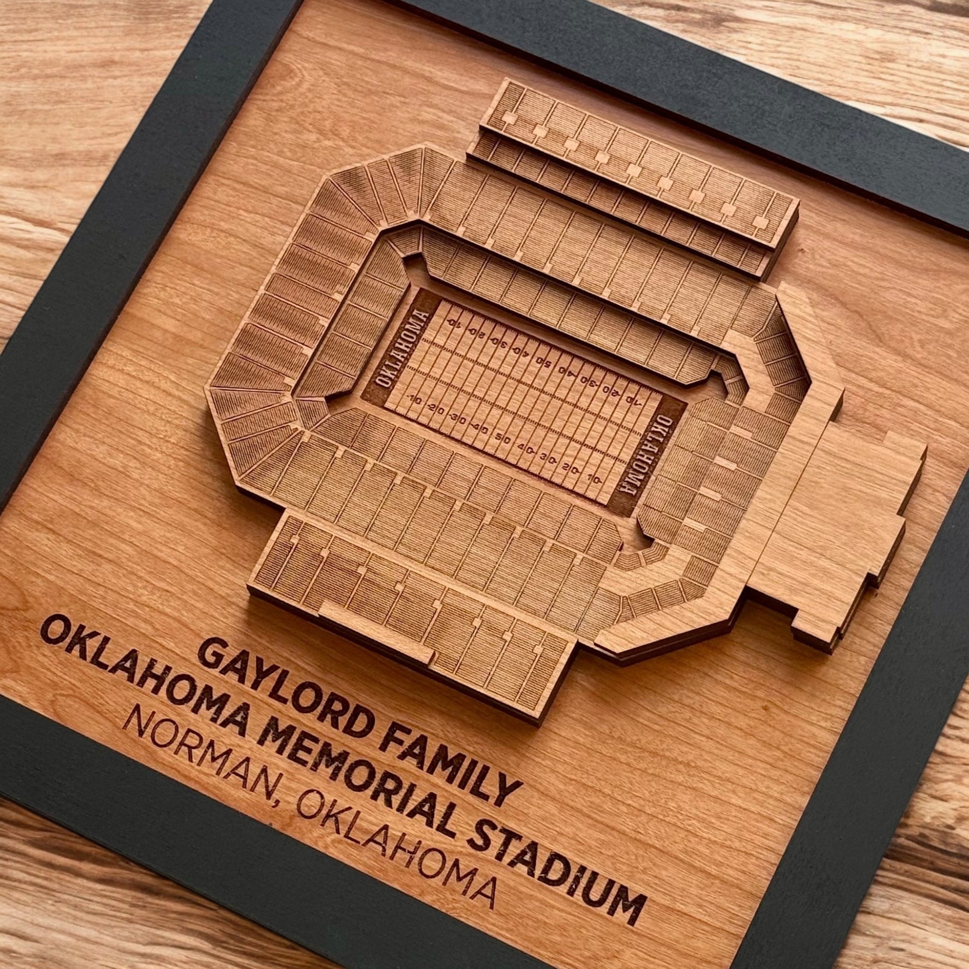 Close up of layered wood stadium seating and engraved field details in Oklahoma Memorial Stadium art