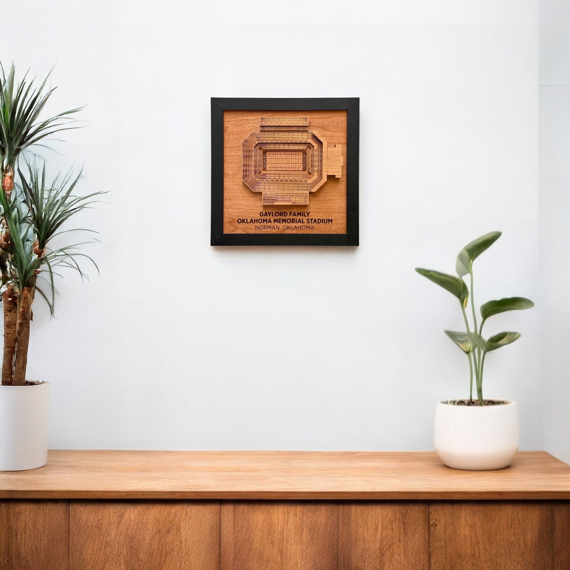 Gaylord Family Oklahoma Memorial Stadium wooden wall art displayed on a white wall above a wood console