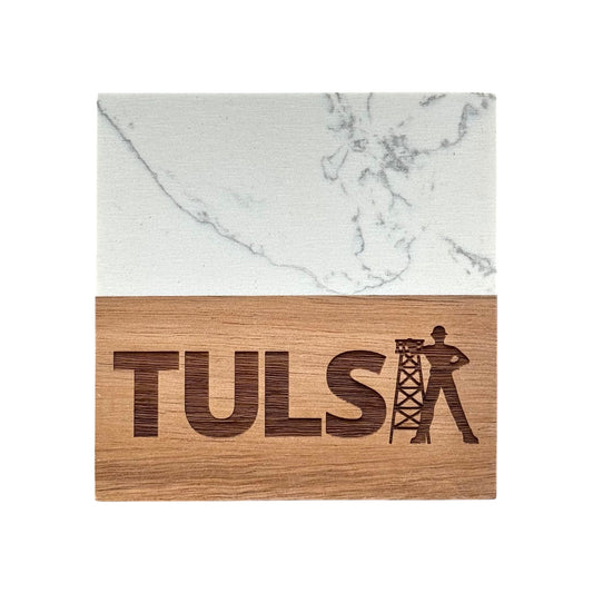 Close-up of Tulsa coaster made from marble and acacia wood, engraved with bold Tulsa lettering and Golden Driller design.