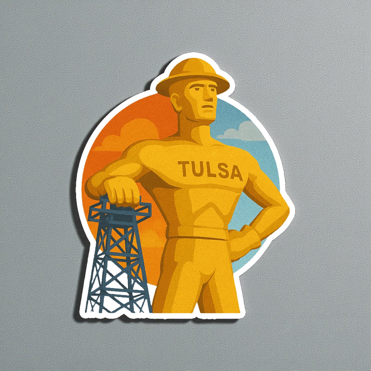 Die cut Tulsa Golden Driller sticker displayed on a neutral wall surface, detailed Tulsa landmark artwork with oil derrick and sunset sky