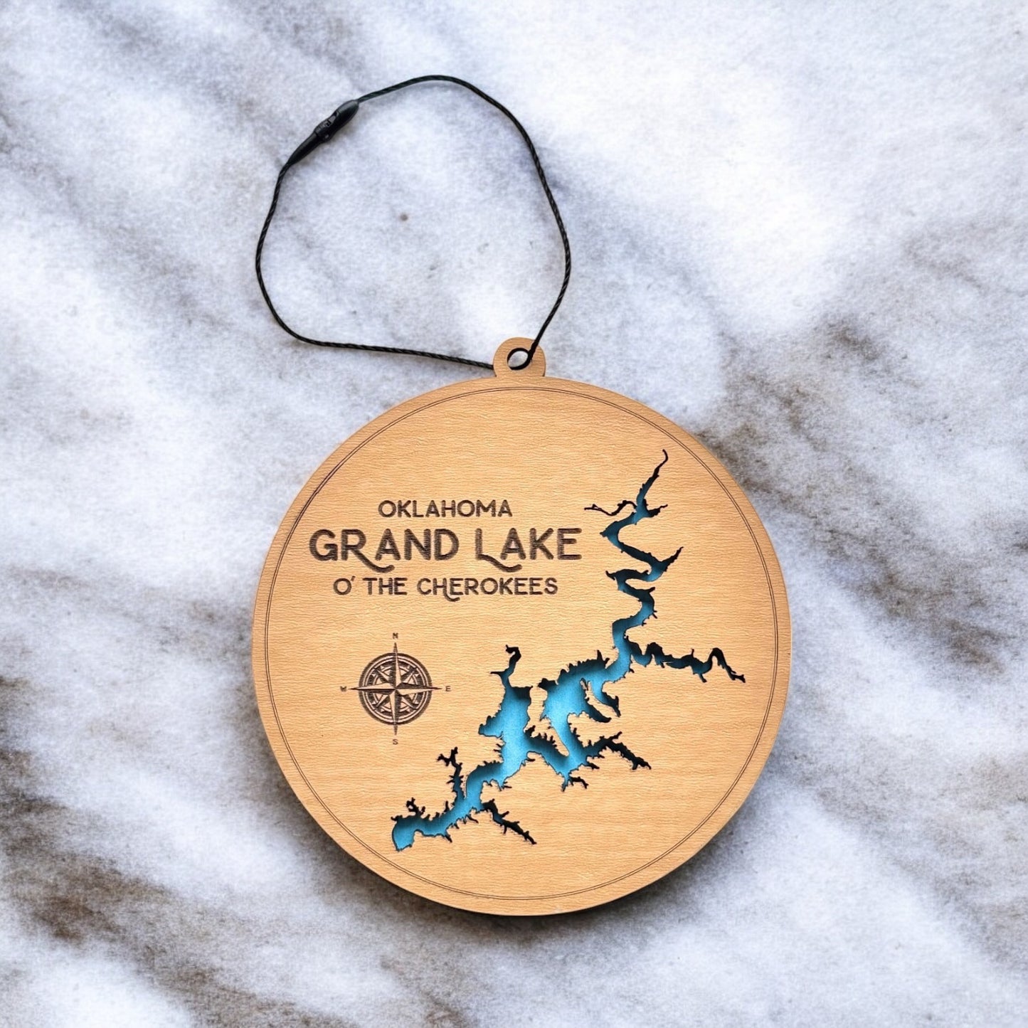 Grand Lake O the Cherokees layered wooden ornament displayed on marble surface with engraved lake name and compass detail