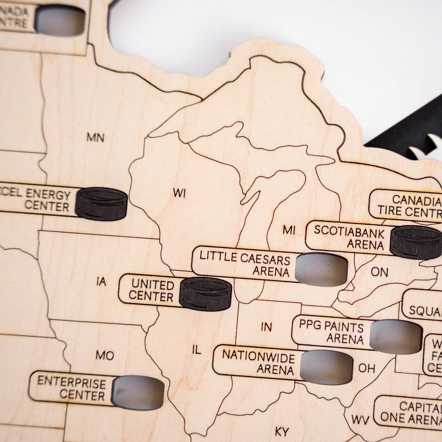 Close up detail of hockey stadium map showing Midwest arena locations engraved into layered wood USA map