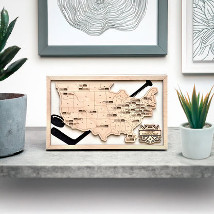 Hockey stadium map displayed on shelf with modern home decor, framed wood USA hockey arena travel tracker for hockey fans