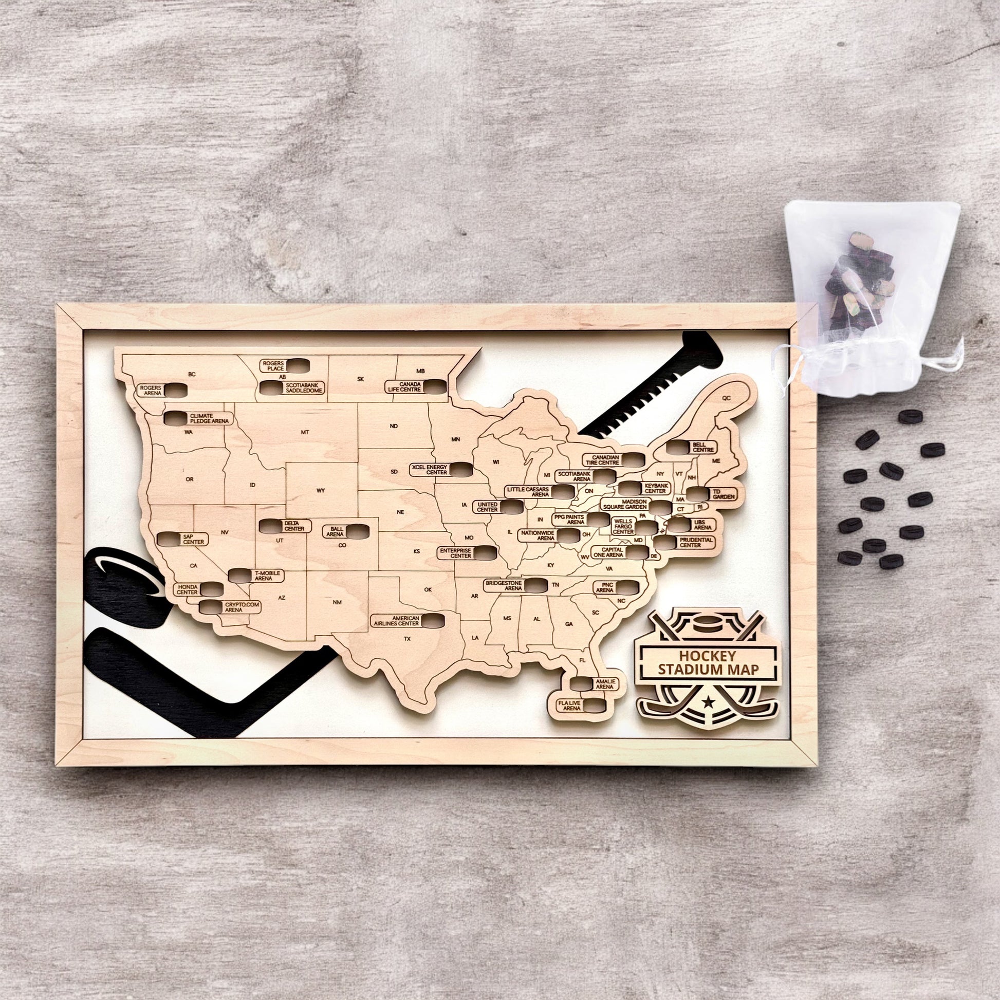 Flat lay of framed hockey stadium map with wooden puck markers and hockey stick design elements, USA hockey travel tracker decor