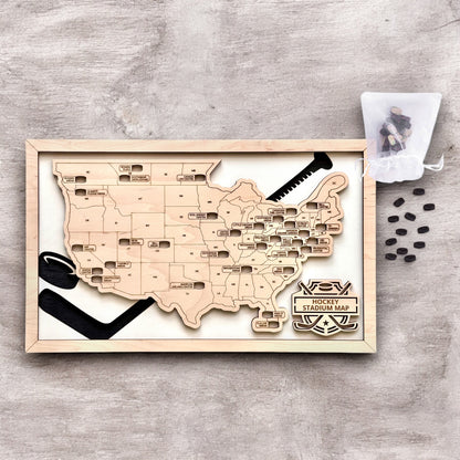 Flat lay of framed hockey stadium map with wooden puck markers and hockey stick design elements, USA hockey travel tracker decor
