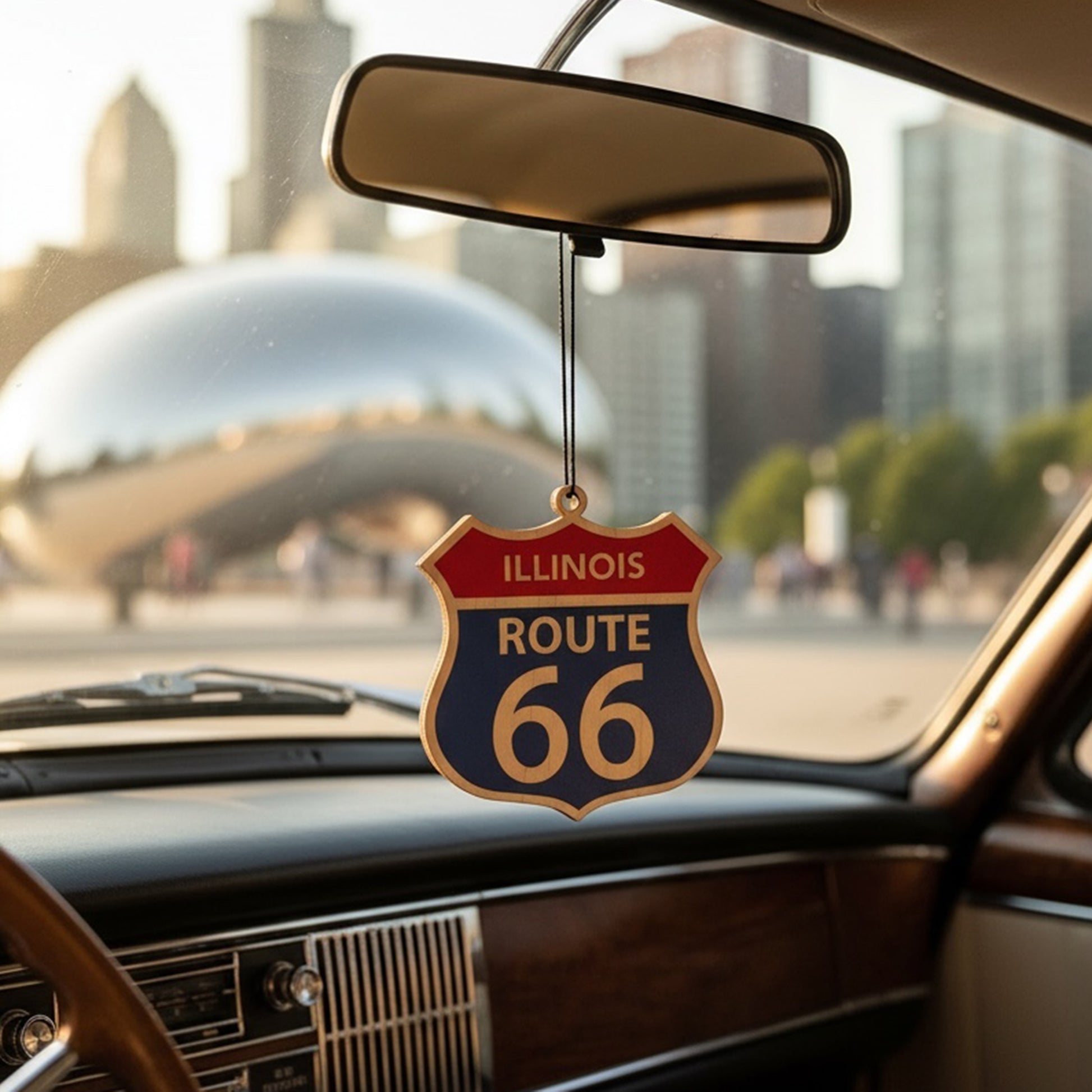 Illinois Route 66 shield wood ornament hanging from a car rearview mirror with Chicago skyline in background, Americana road trip decor inspired by historic Route 66 travel