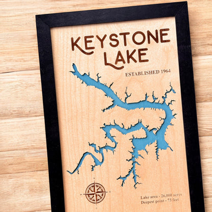 Close up angled view of Keystone Lake wooden map showing laser cut shoreline, engraved text, and blue layered water detail