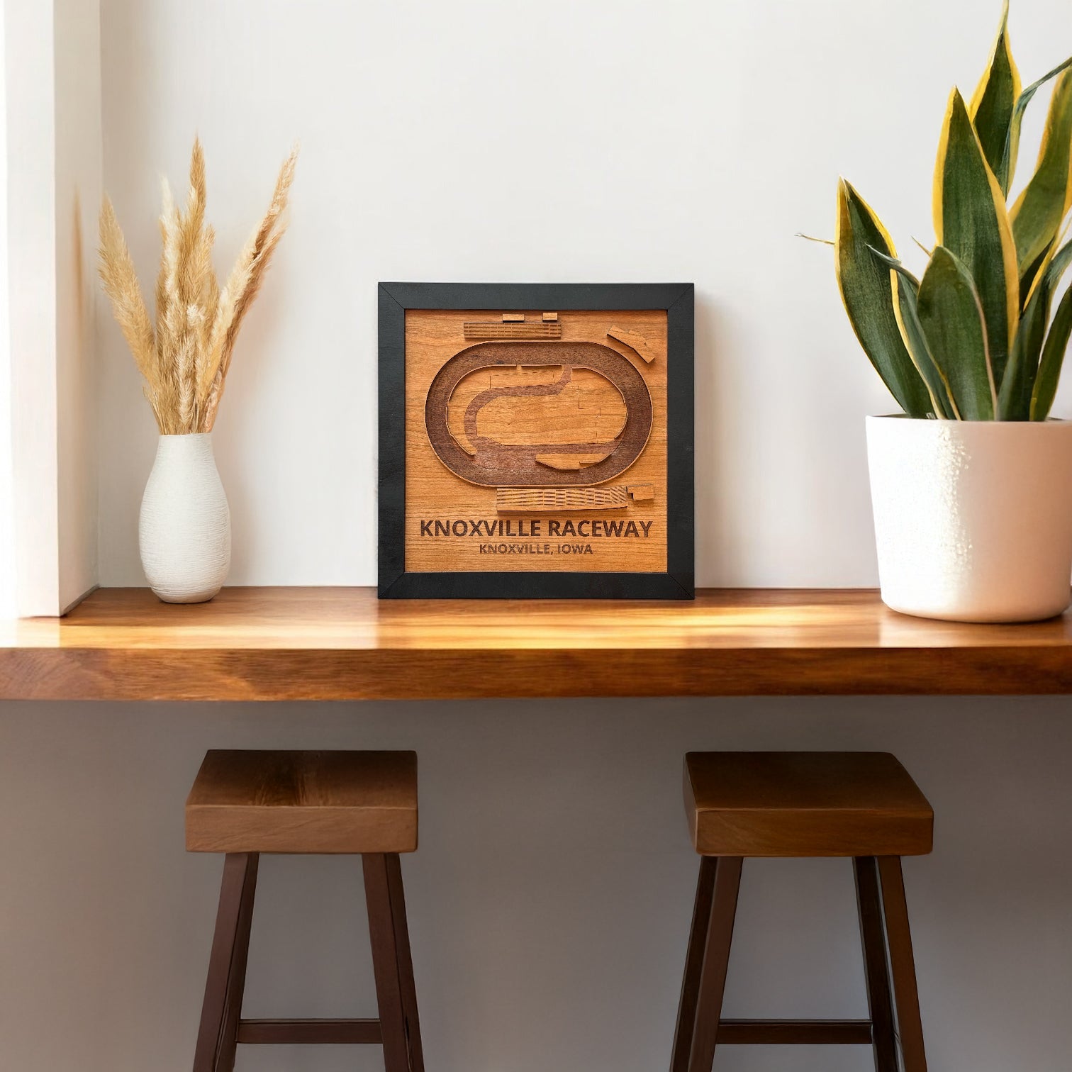 Knoxville Raceway wooden track map wall art displayed on a shelf in a modern home setting, framed laser cut wood race track decor for sprint car racing fans and Knoxville Iowa souvenir
