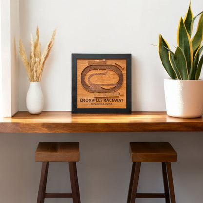 Knoxville Raceway wooden track map wall art displayed on a shelf in a modern home setting, framed laser cut wood race track decor for sprint car racing fans and Knoxville Iowa souvenir
