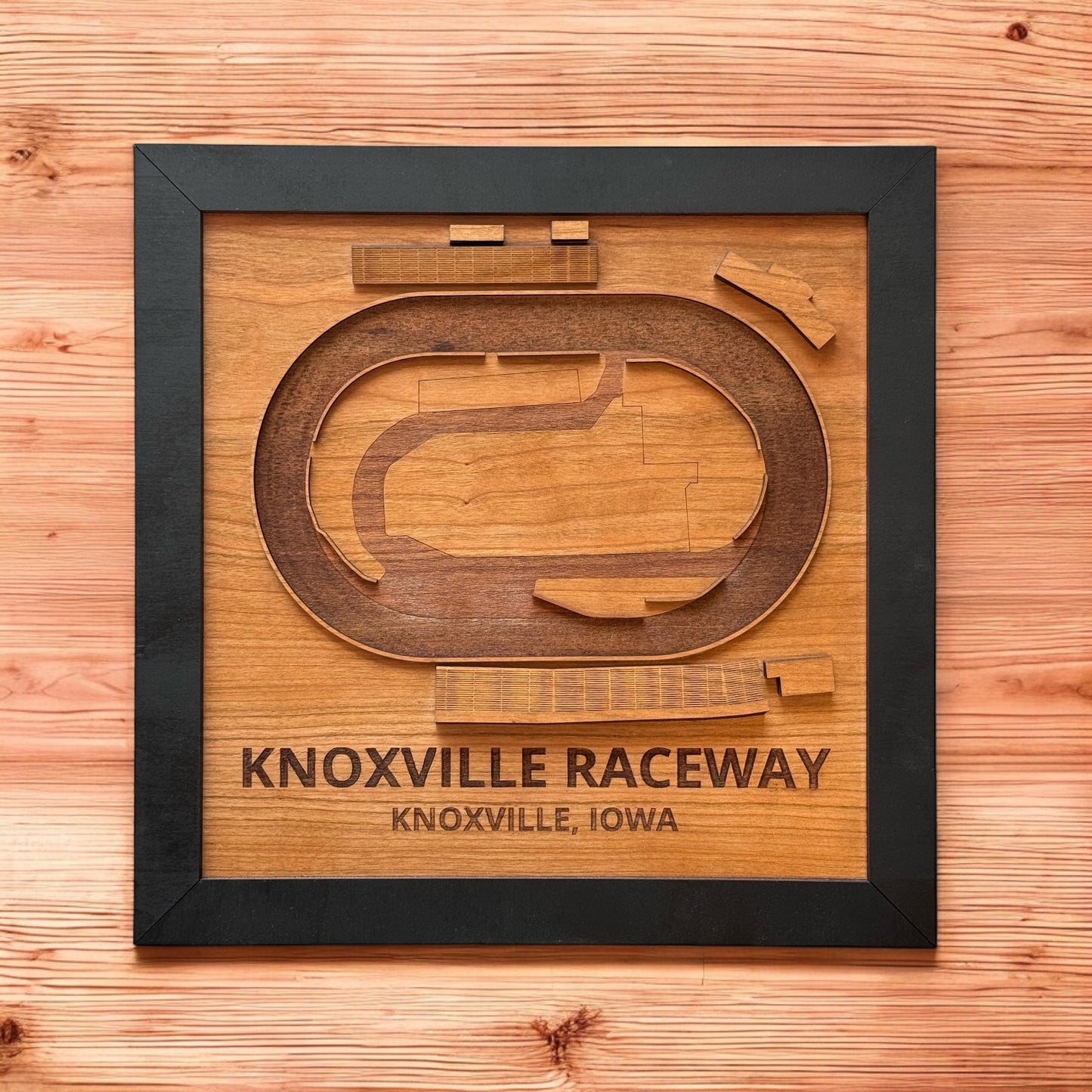 Framed Knoxville Raceway wooden track map photographed flat lay on wood surface, layered laser cut wood race track wall art featuring Knoxville Iowa motorsports landmark
