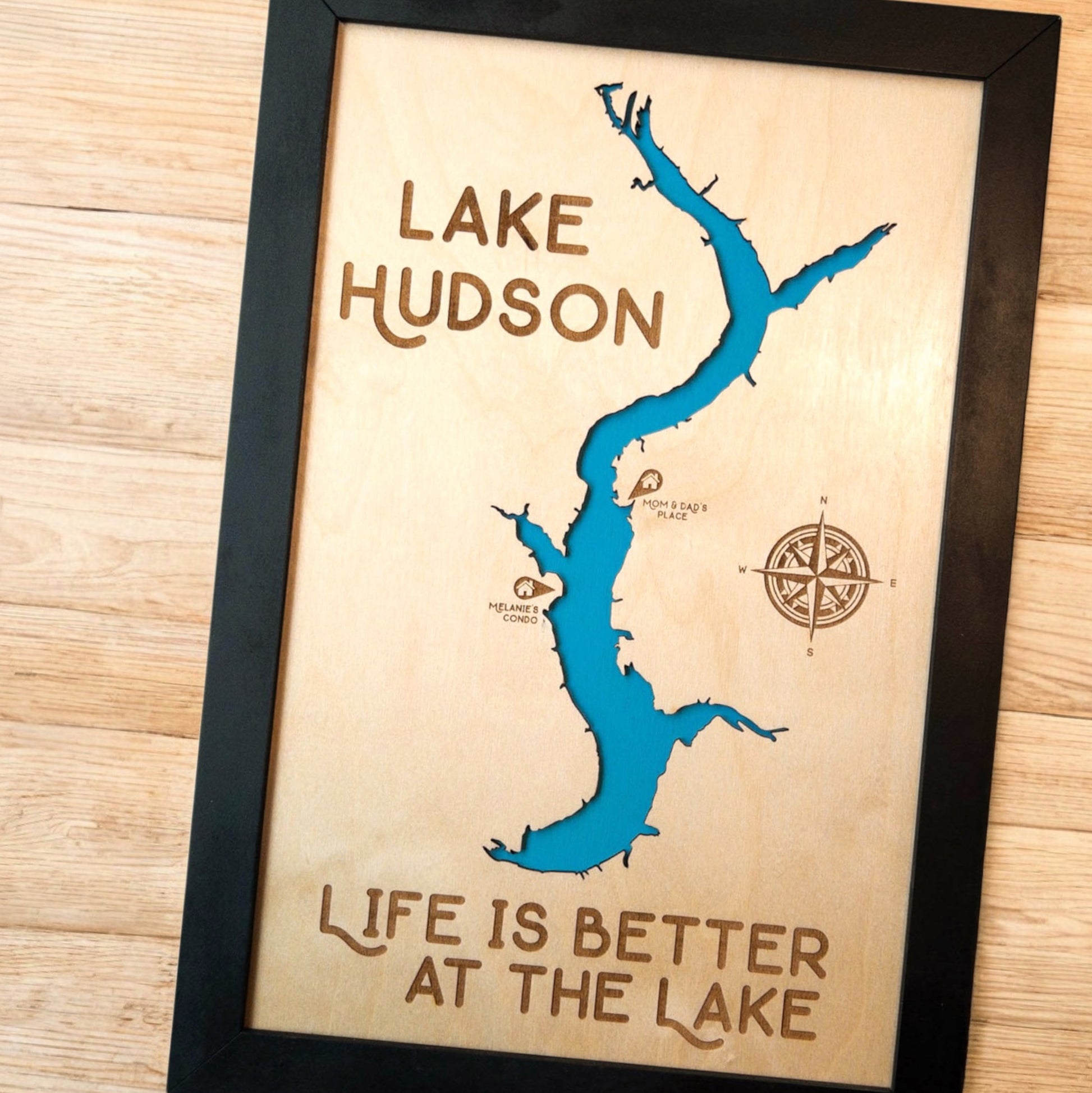 Close up of Lake Hudson wood map showing blue lake backing, engraved compass rose, and shoreline detail