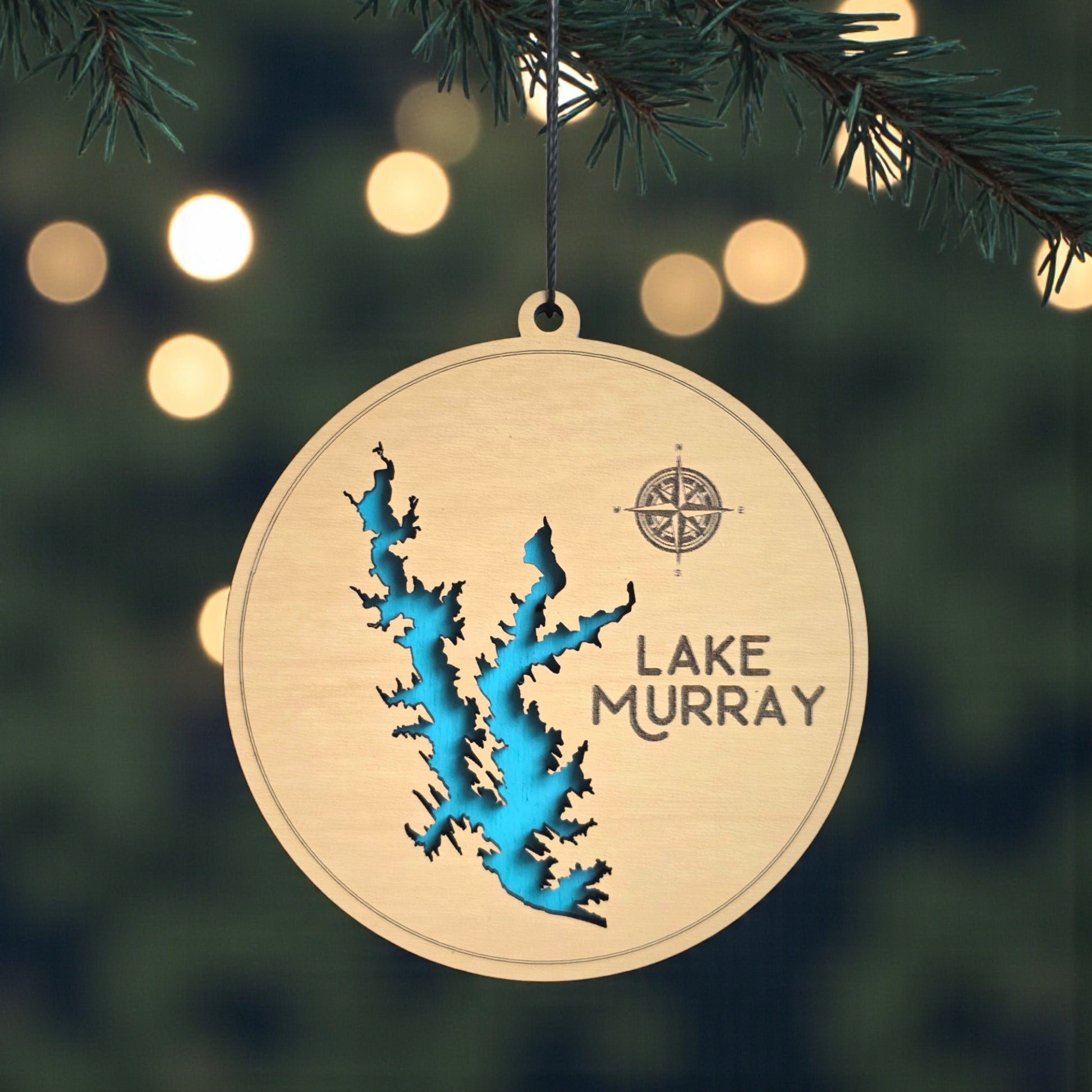 Lake Murray wooden ornament hanging on evergreen tree with lights, layered wood lake map ornament with blue painted water detail and hanging cord