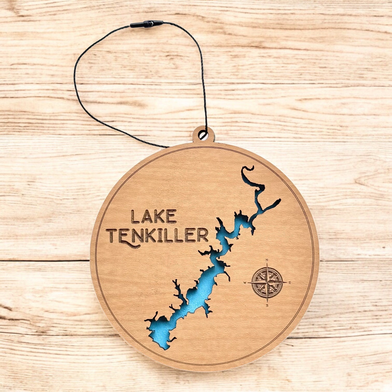 Lake Tenkiller layered wood ornament shown on wood surface, round lake map ornament with engraved text and blue water detail