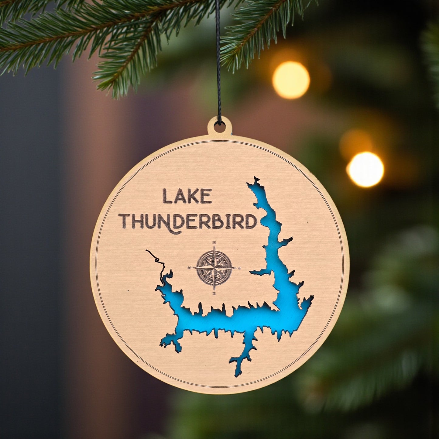Lake Thunderbird wooden ornament hanging on evergreen tree, laser cut wood lake map ornament with blue inlay used as Oklahoma lake Christmas decor or travel keepsake
