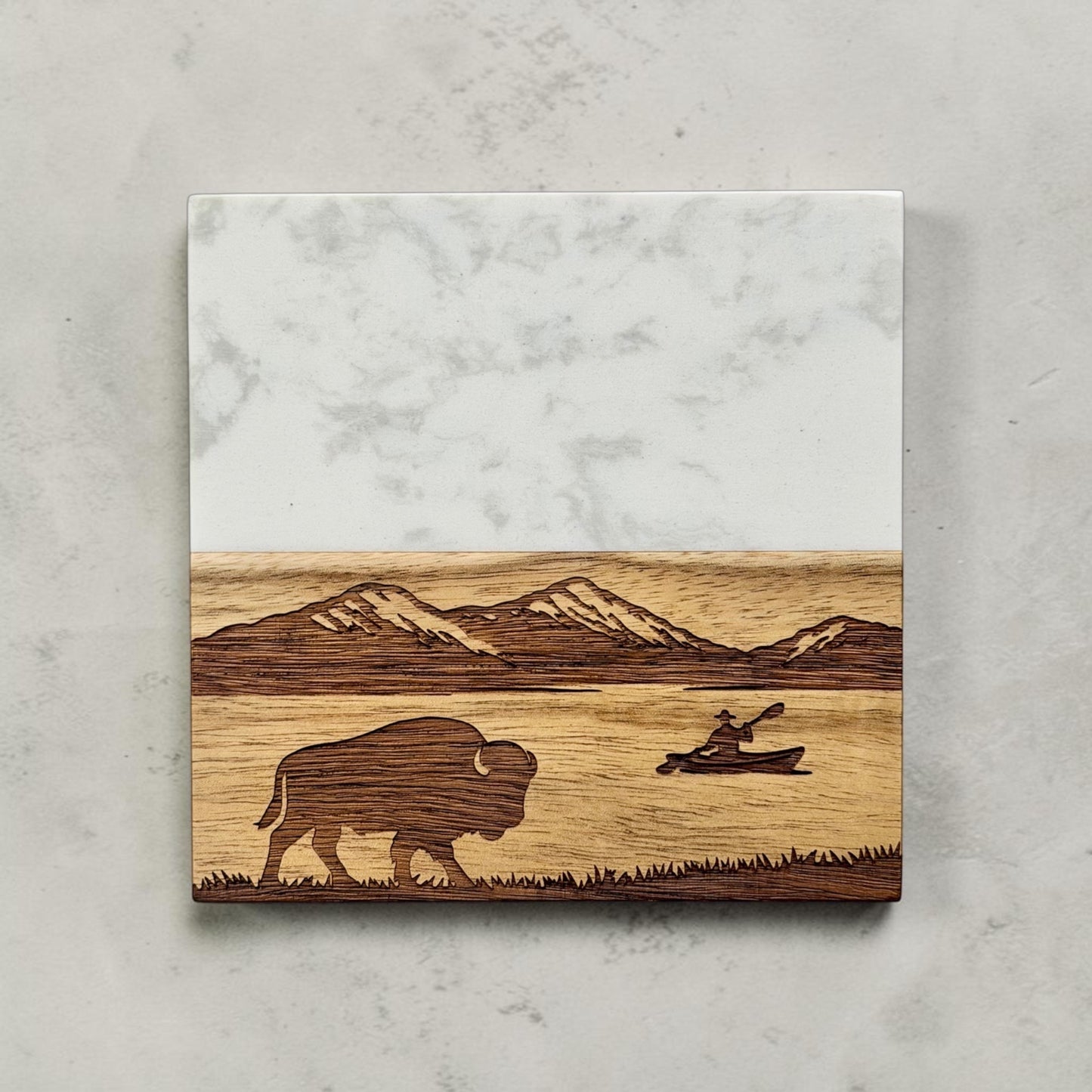Marble and acacia wood coaster with laser engraved mountain lake landscape featuring a walking bison and kayaker, rustic wilderness drink coaster for cabin decor or outdoor themed gift