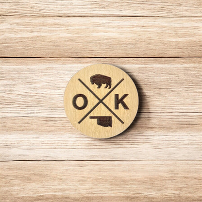 Back of OK wooden pin showing metal post and black rubber pin back, lightweight round wood lapel pin for hats and jackets