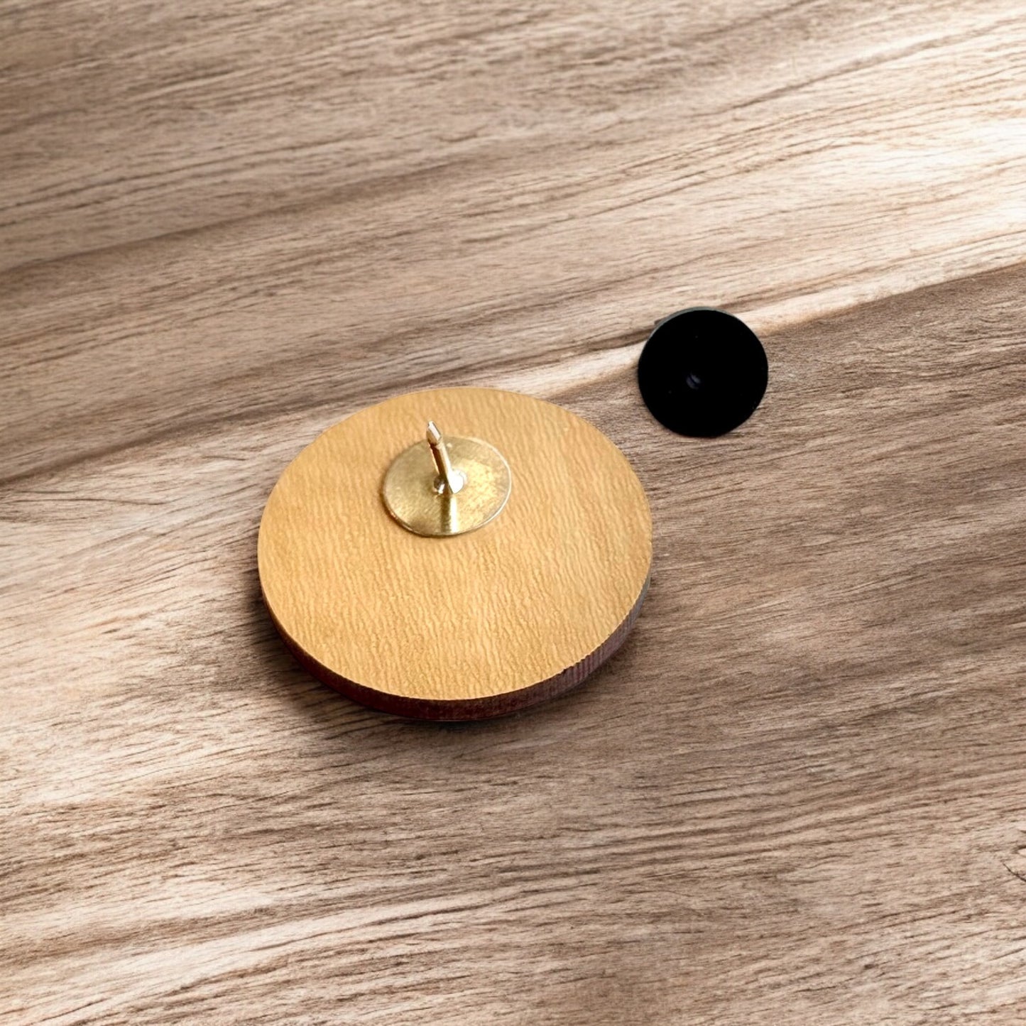 OK X wooden lapel pin on white background with engraved bison and Oklahoma icons, minimalist Oklahoma wood pin souvenir