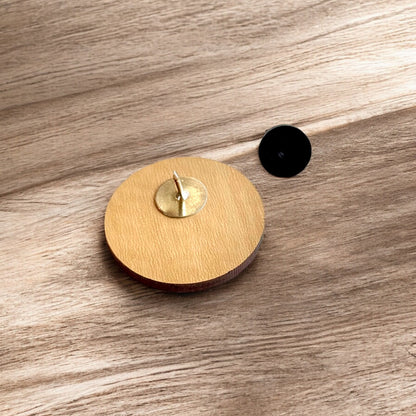 OK X wooden lapel pin on white background with engraved bison and Oklahoma icons, minimalist Oklahoma wood pin souvenir