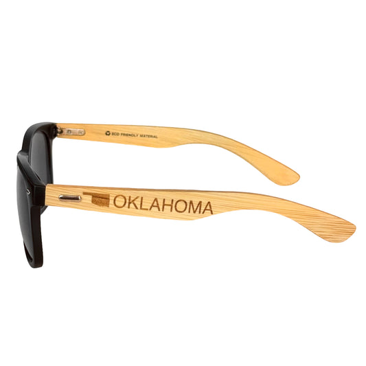 Oklahoma bamboo sunglasses with black matte frame shown from the side, engraved Oklahoma state outline and text on natural bamboo arms, souvenir sunglasses for Oklahoma travel gift