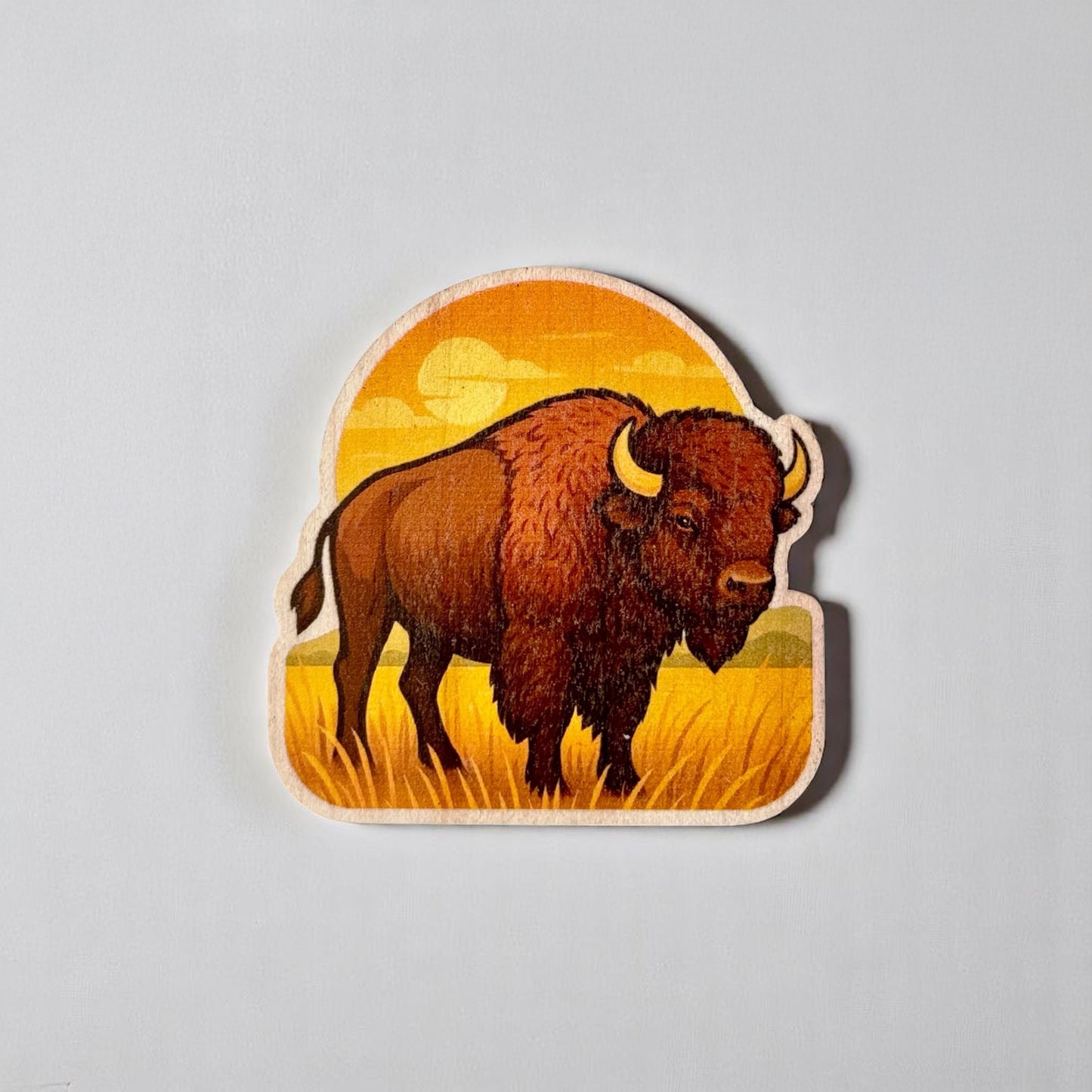 Flat lay of Oklahoma bison wood sticker on neutral background, printed wooden sticker with visible wood grain and prairie landscape design