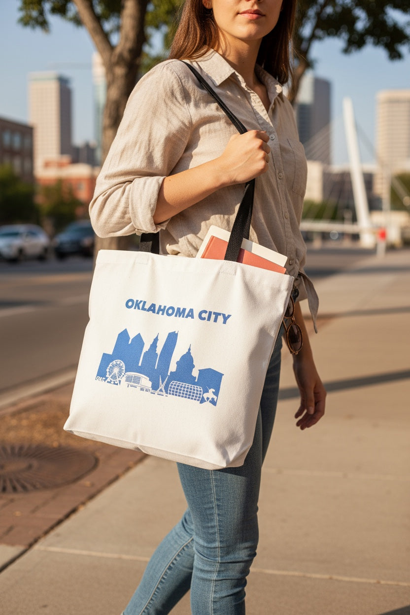 Oklahoma City skyline tote bag being carried outdoors, blue OKC skyline design on canvas tote used as everyday city bag
