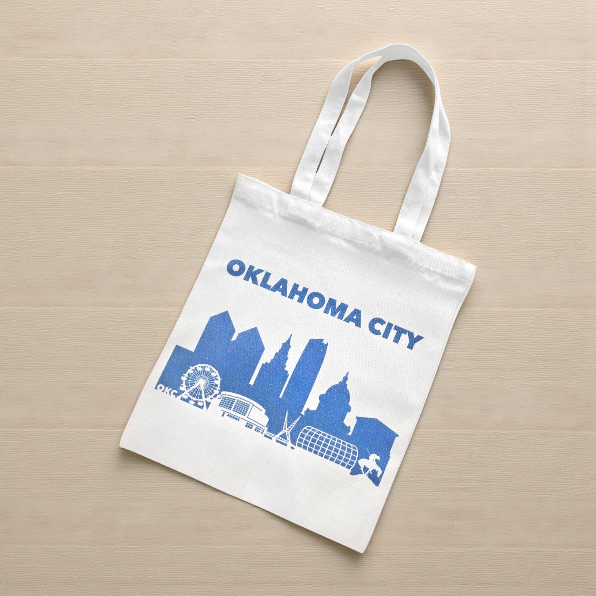 Flatlay of small Oklahoma City skyline tote bag in blue, eco-friendly Oklahoma souvenir tote.