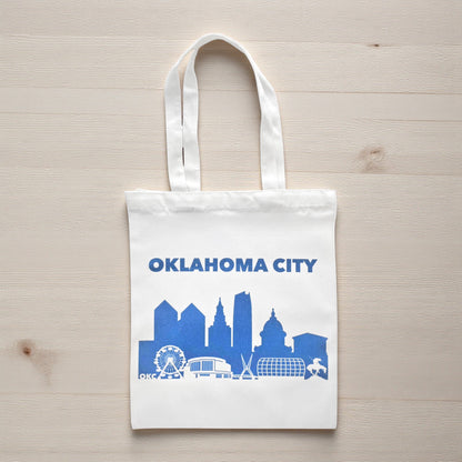 Oklahoma City skyline tote bag in blue on a wooden table, Oklahoma-themed reusable shopping bag.