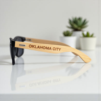 Close-up side view of Oklahoma City engraved wooden sunglasses featuring OKC text, modern Route 66 souvenir by The Curious Bison.