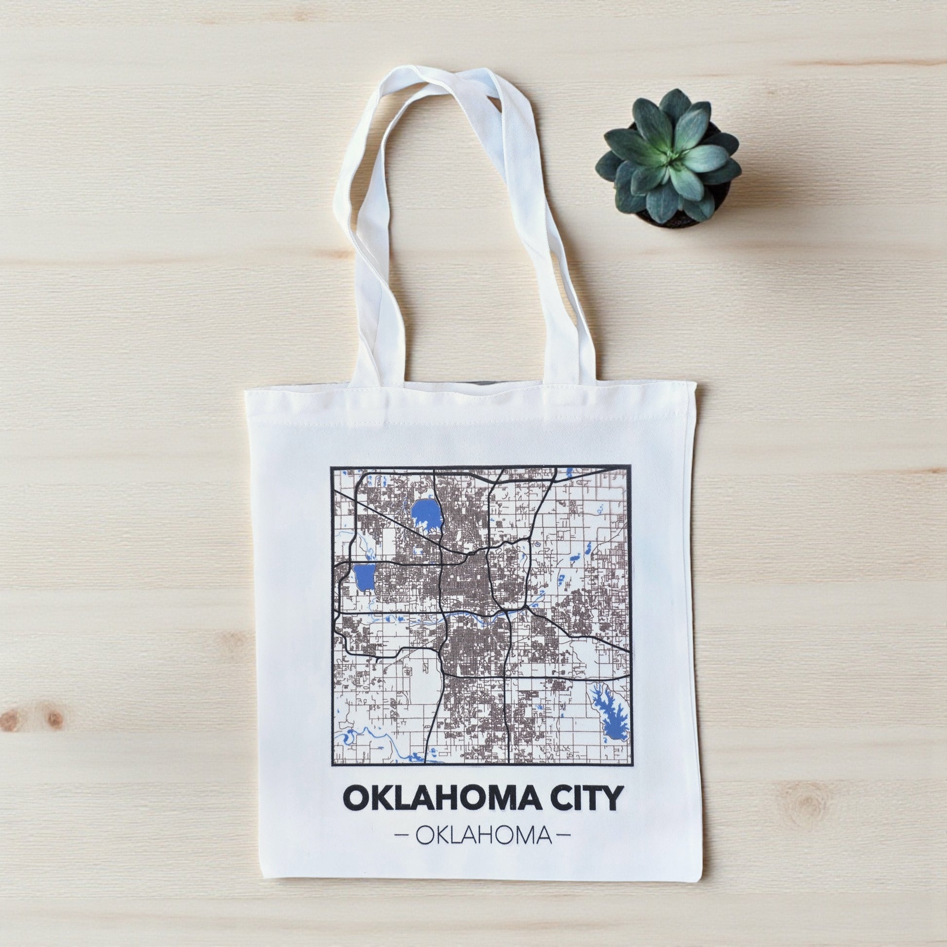 Small Oklahoma City map tote bag flat lay on wood surface, compact city map tote with white handles for errands or souvenirs