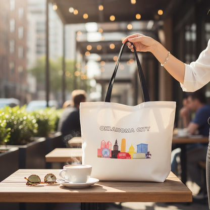 Oklahoma City Pride tote bag with rainbow OKC skyline sitting on a coffee shop table, LGBTQIA inclusive souvenir from Oklahoma.