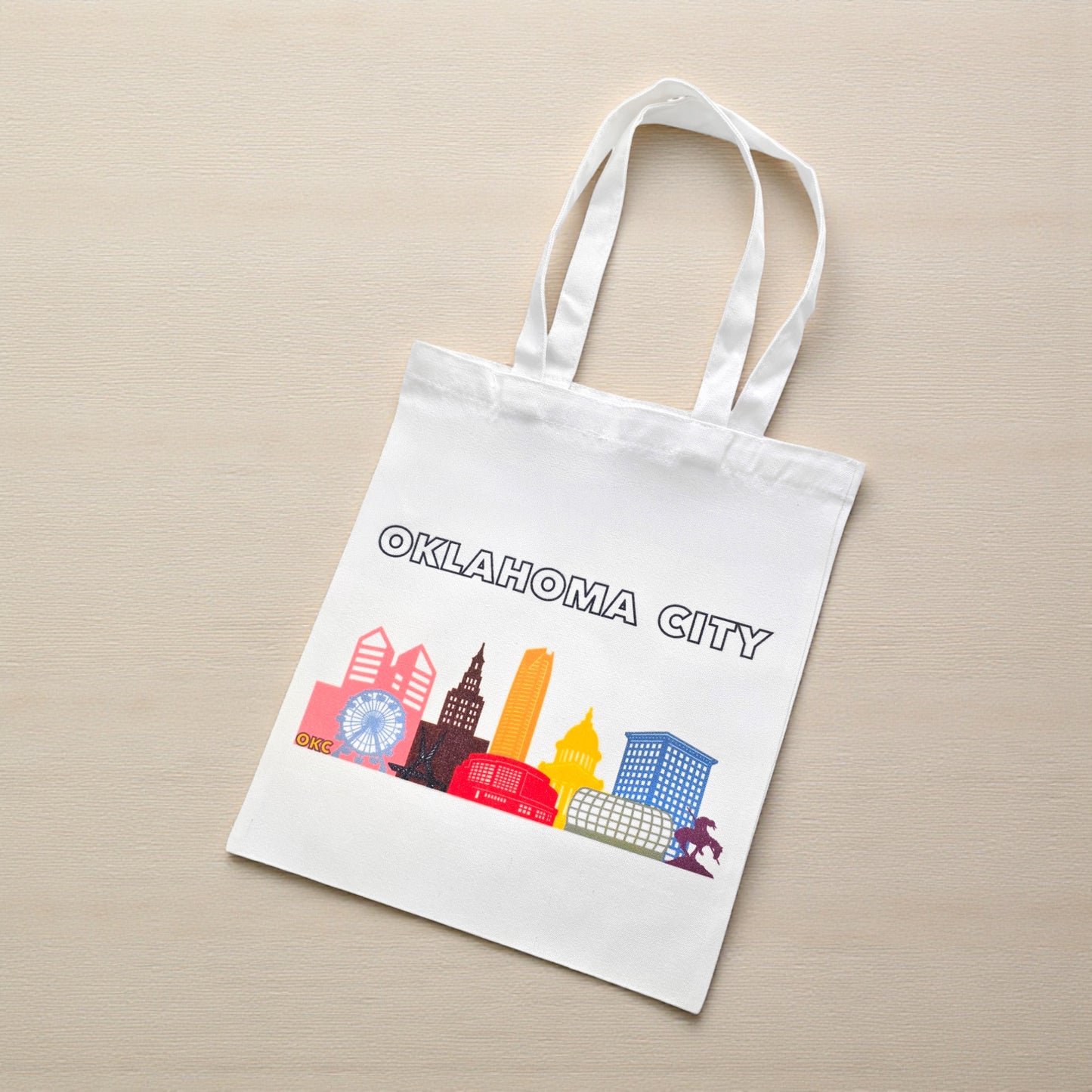 Flatlay of Oklahoma City Pride small tote bag with colorful skyline design, eco-friendly OKC gift celebrating LGBTQIA pride.