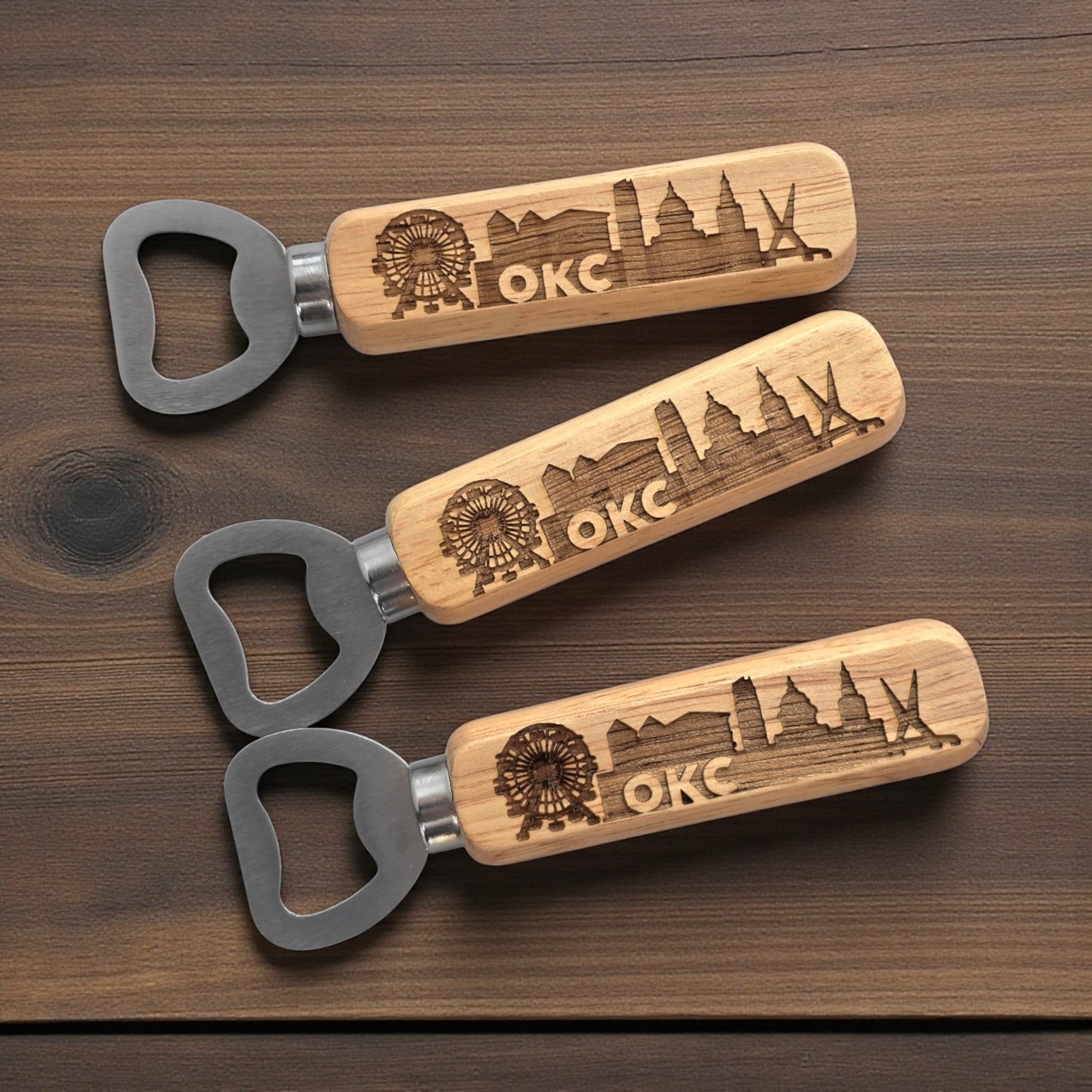 Set of three Oklahoma City skyline bottle openers displayed on a wooden surface, engraved OKC souvenirs by The Curious Bison.