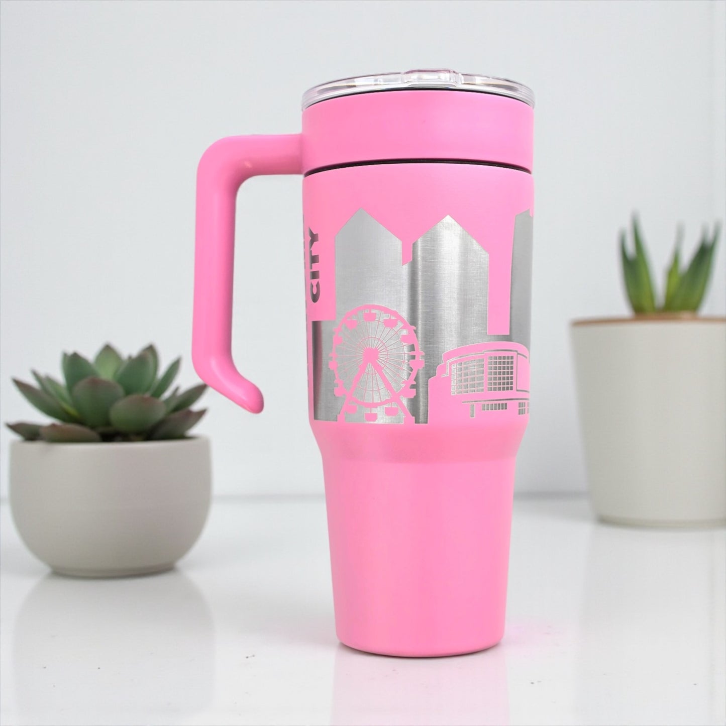 Pink Oklahoma City Skyline tumbler showing engraved Oklahoma landmarks and modern cityscape, handcrafted travel mug by The Curious Bison.