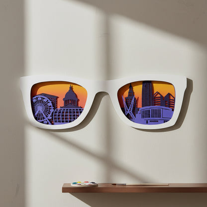 White sunglasses shaped layered wood wall art displaying Oklahoma City skyline with city landmarks and sunset gradient background, decorative OKC wall art for living room, Oklahoma gift, and Route 66 travel decor