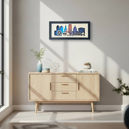 Framed Oklahoma City skyline layered wood wall art hanging above a light wood cabinet, featuring a starry night sky backdrop and OKC landmarks.