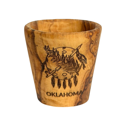 Oklahoma flag olive wood shot glass with laser engraved Osage shield, peace pipe, olive branch and Oklahoma lettering, wooden state souvenir shown from the front