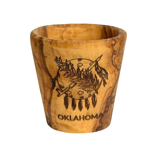 Oklahoma flag olive wood shot glass with laser engraved Osage shield, peace pipe, olive branch and Oklahoma lettering, wooden state souvenir shown from the front
