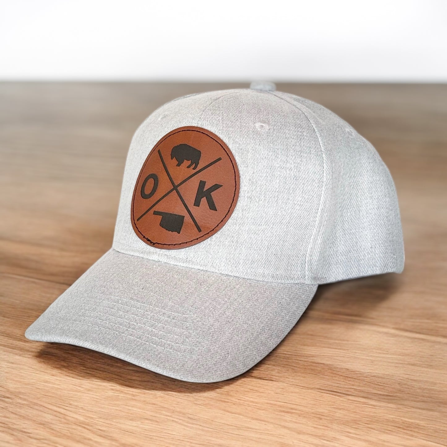 Angled view of gray baseball hat with Oklahoma leatherette patch snapback hat, Oklahoma souvenir and travel gift