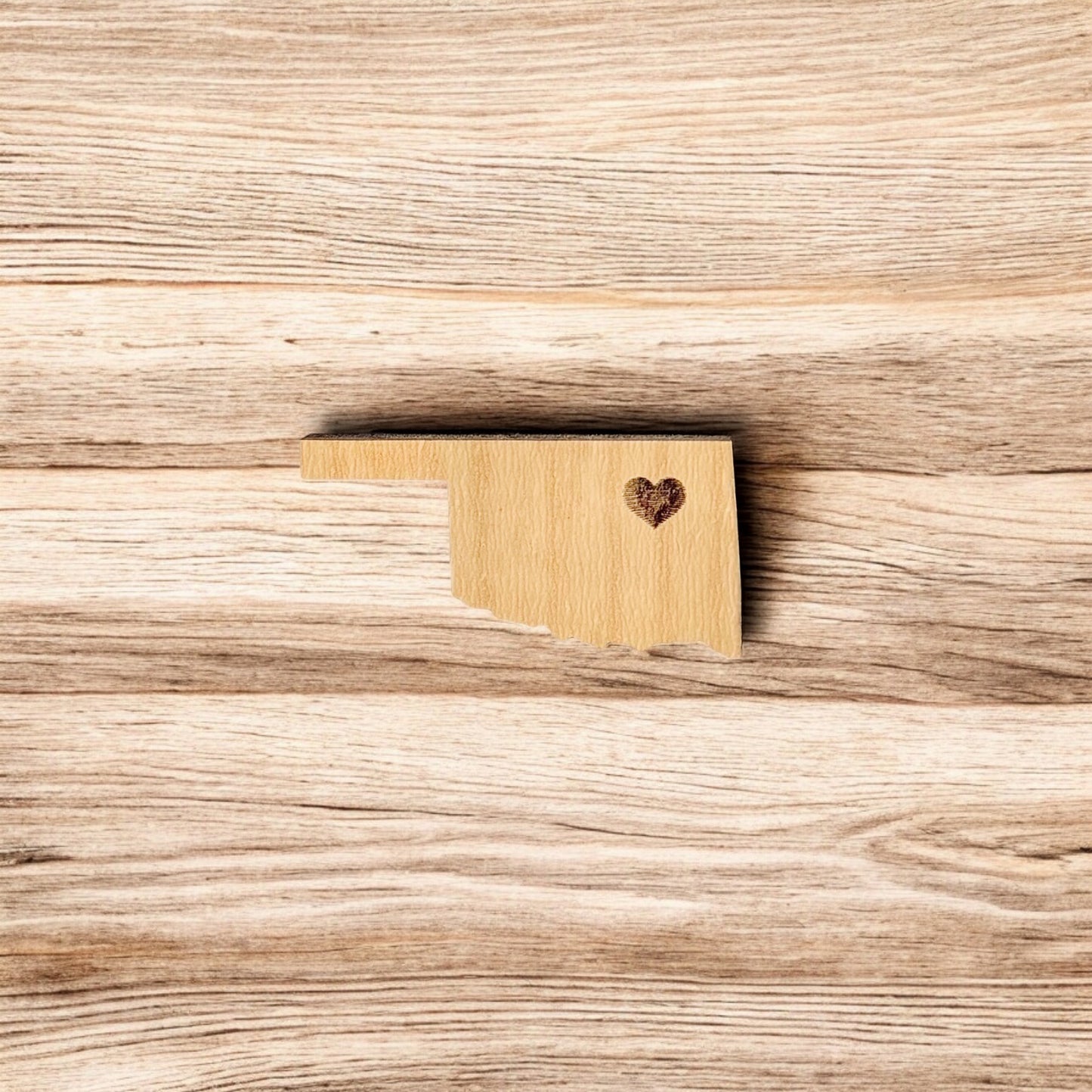 Back of Oklahoma heart wooden pin showing metal post and black rubber pin back, lightweight wooden lapel pin for hats and jackets