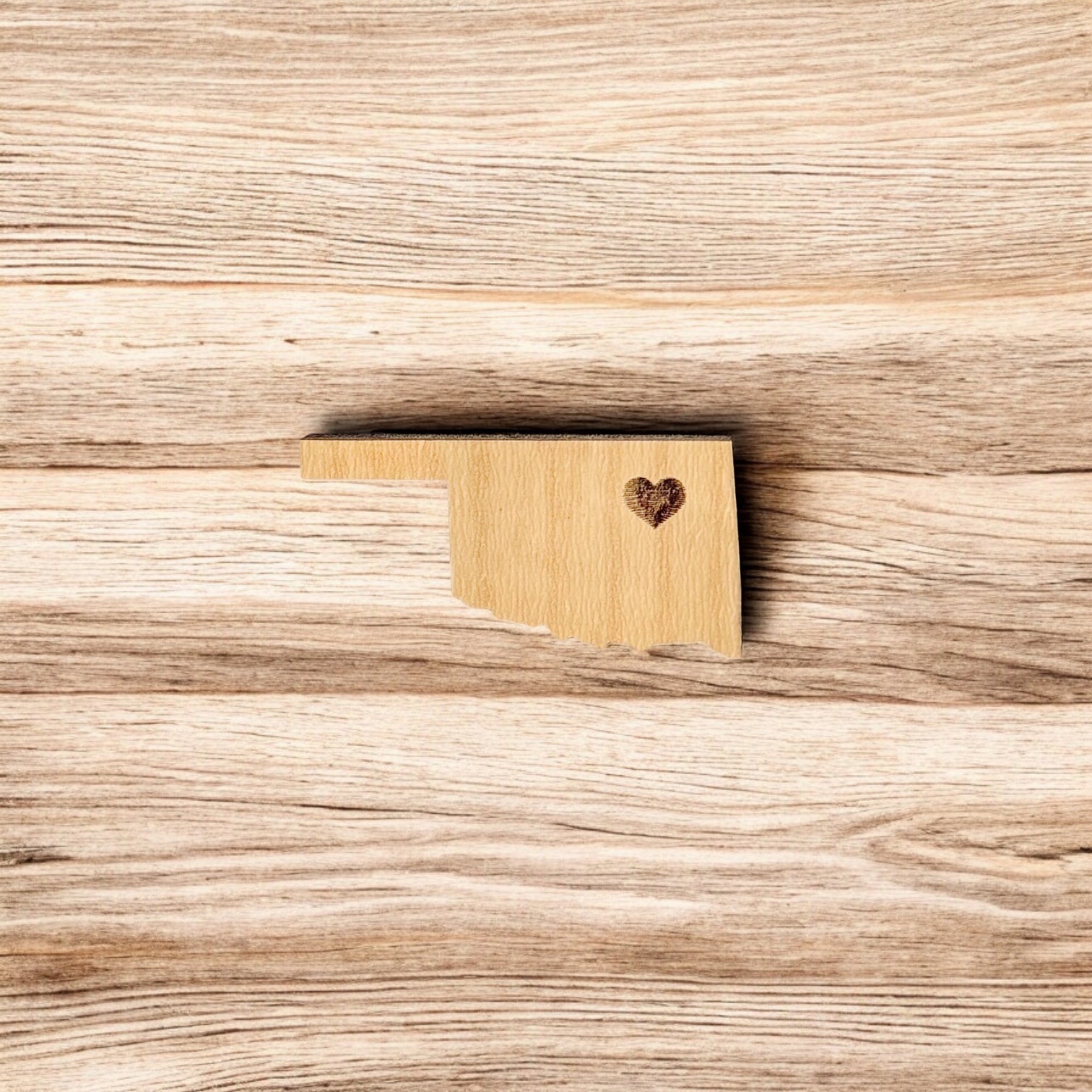Back of Oklahoma heart wooden pin showing metal post and black rubber pin back, lightweight wooden lapel pin for hats and jackets