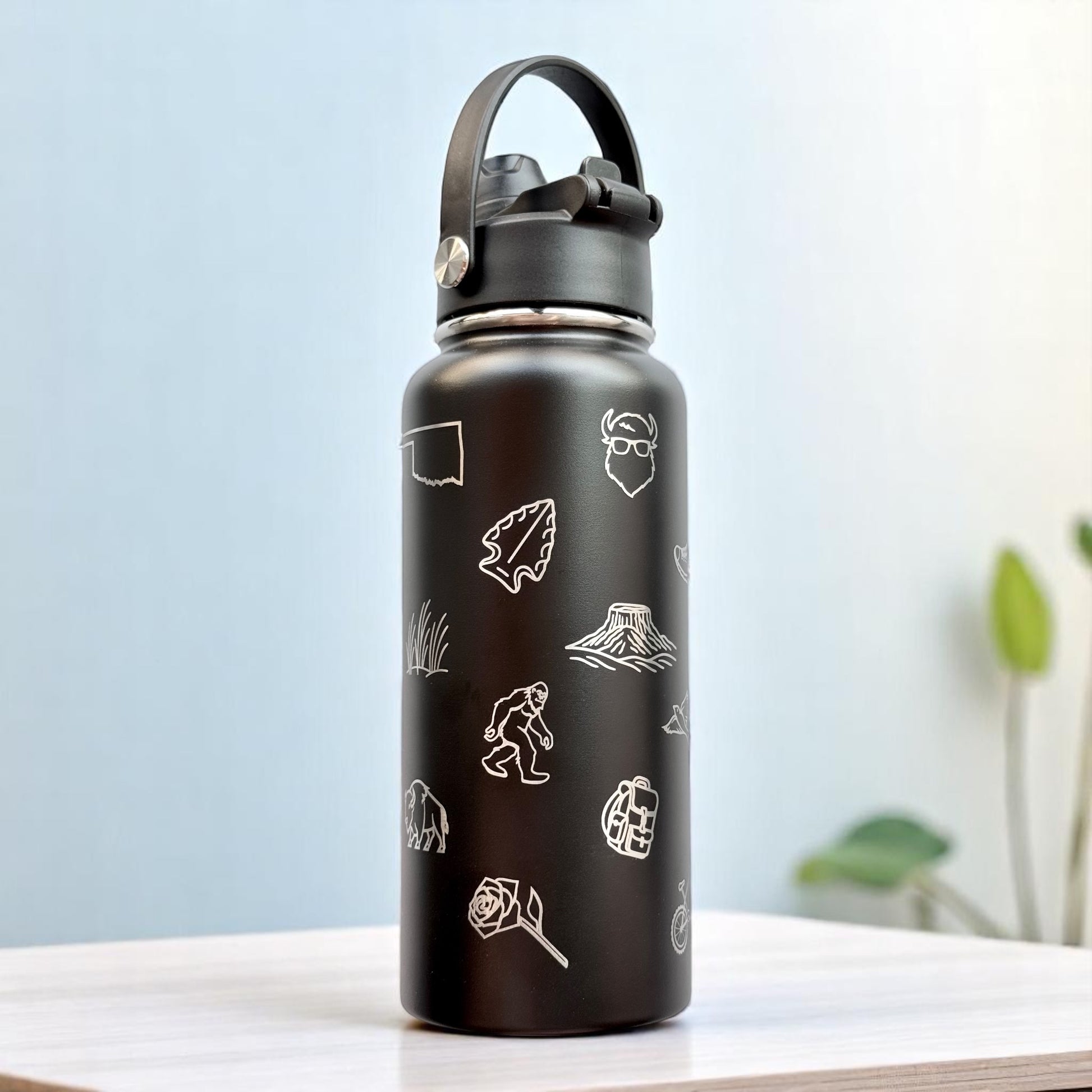 Side view of black Oklahoma icons stainless steel water bottle with engraved bison rose and state outline