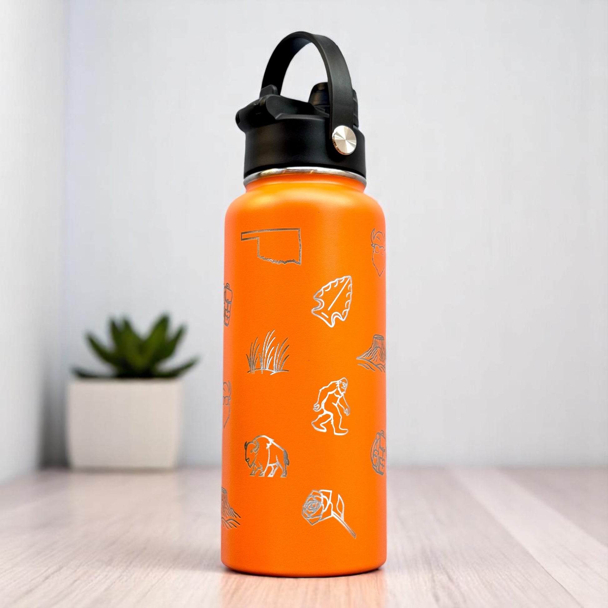 Orange Oklahoma icons insulated water bottle showing laser engraved state outline bison rose and outdoor graphics on stainless steel bottle