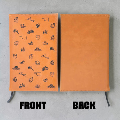 Front and back view of tan leatherette Oklahoma journal showing engraved Oklahoma icon pattern on front, plain back cover and black ribbon bookmark