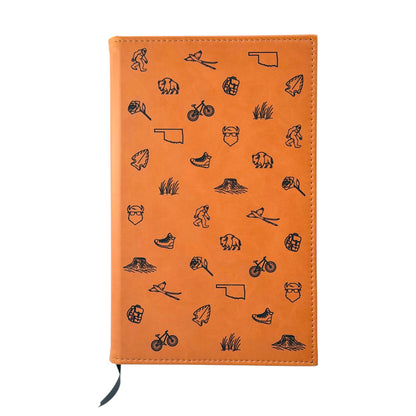 Tan Oklahoma leatherette journal with engraved bison, scissortail, Oklahoma state outline and outdoor icons on the front cover, lined notebook and Oklahoma gift