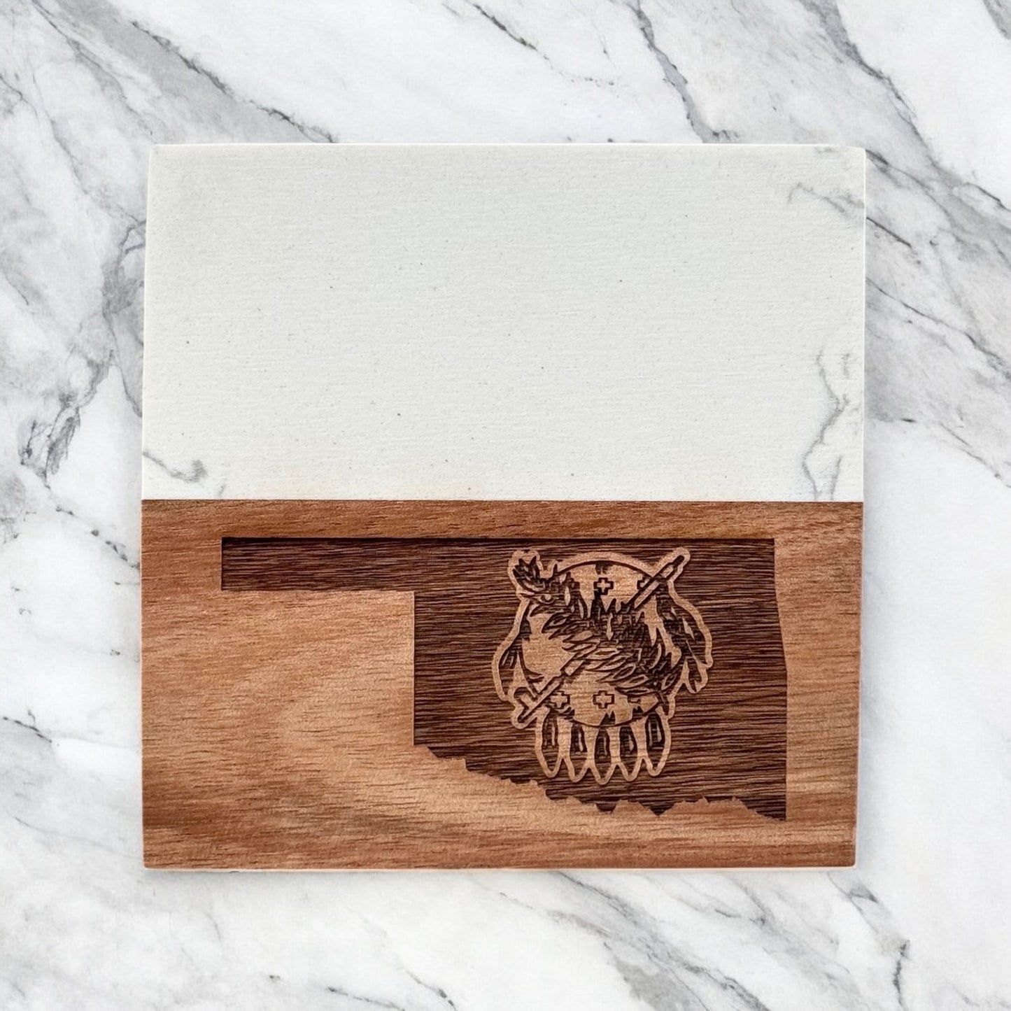 Single Oklahoma marble and acacia wood coaster photographed flat lay on marble surface, engraved Oklahoma state symbol design
