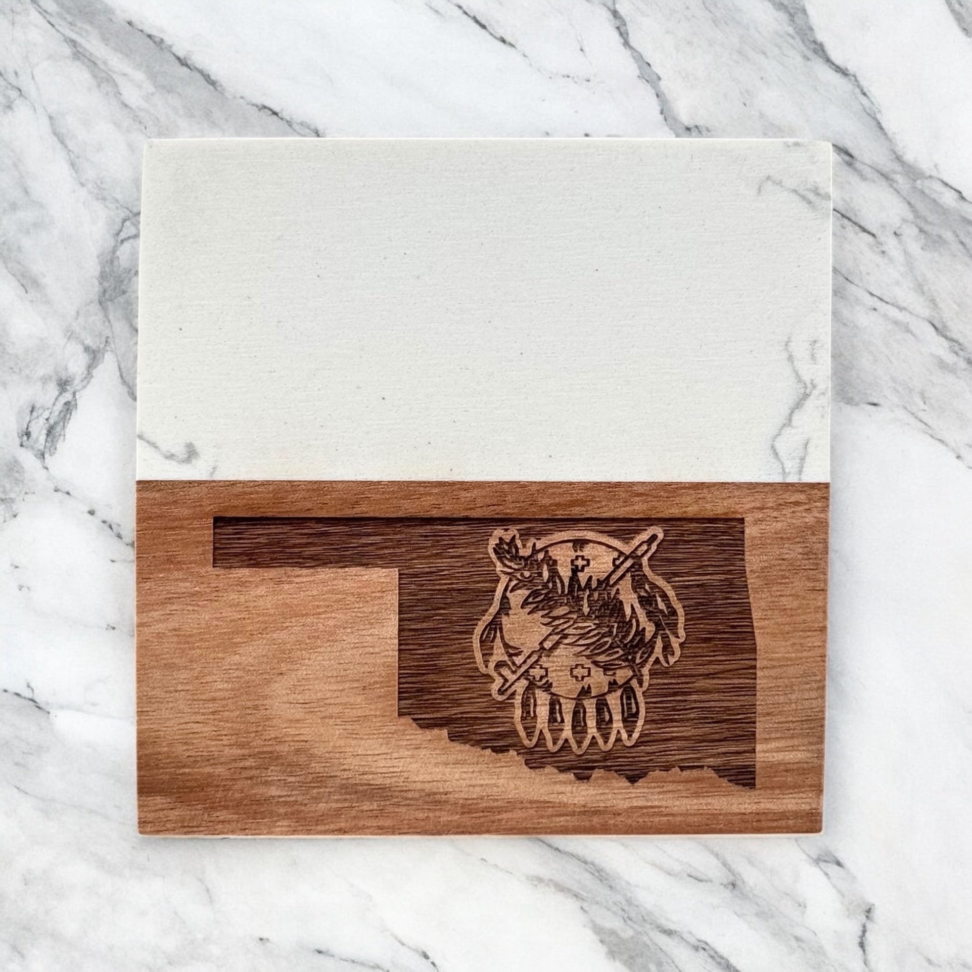 Single Oklahoma marble and acacia wood coaster photographed flat lay on marble surface, engraved Oklahoma state symbol design