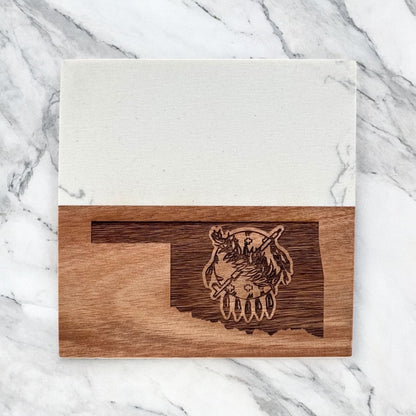 Single Oklahoma marble and acacia wood coaster photographed flat lay on marble surface, engraved Oklahoma state symbol design